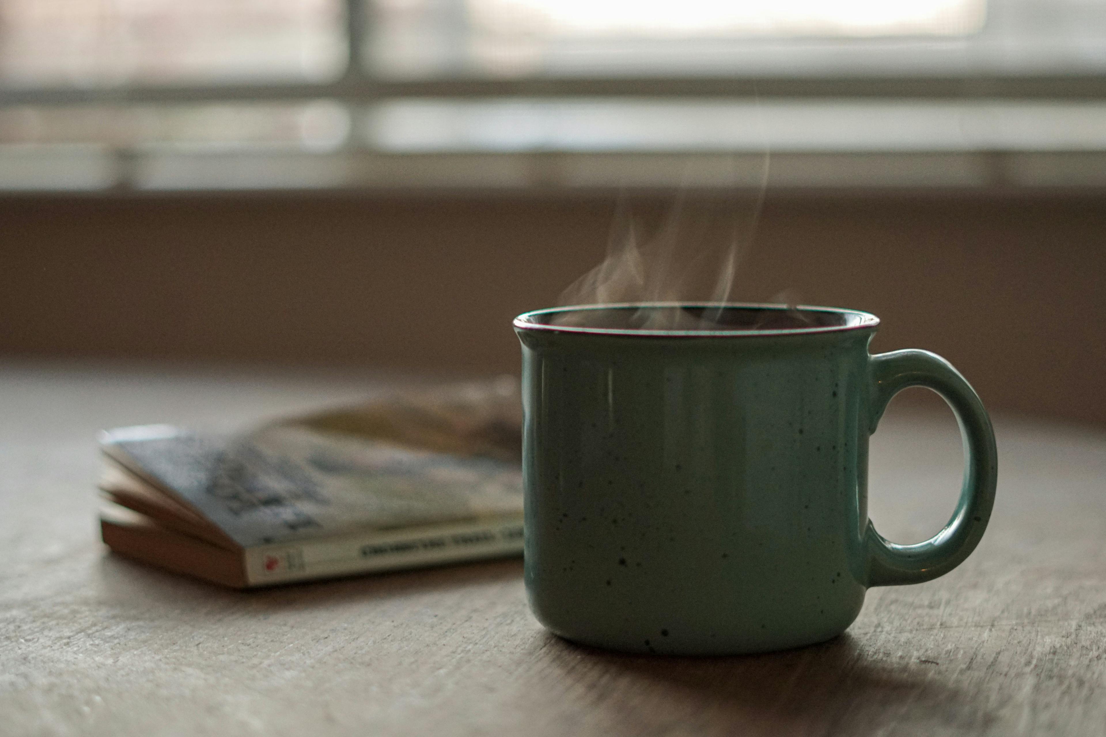 Dampfenden Teetasse mit Buch auf Holztisch