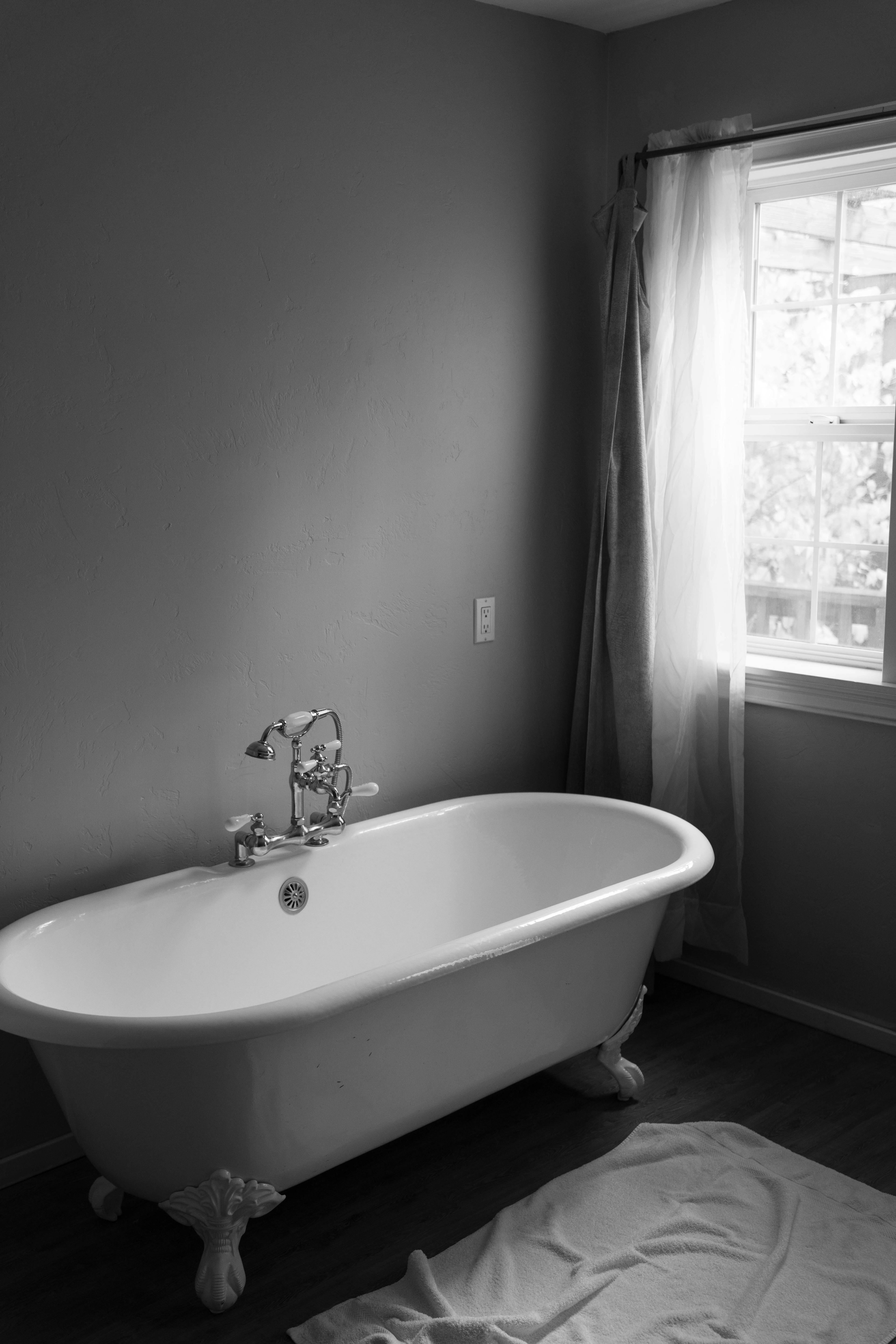 Badezimmer mit Badewanne vor dem Fenster