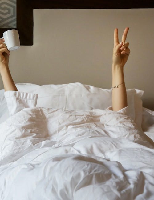 Frau mit Kaffeetasse im Bett